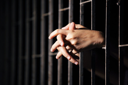 Hands behind prison bars