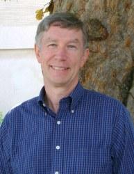 Headshot of Glenn Firebaugh with gray hair and blue plaid shirt.