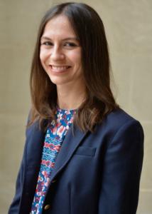 Butler with long straight brown hair and blue jacket