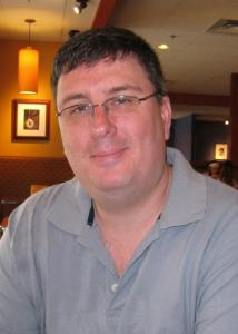 Headshot of Donald Miller with short dark hair, thin rimmed glasses and a grey collared shirt.