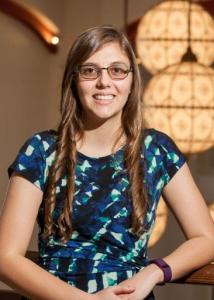 Ford with long hair glasses and blue print dress