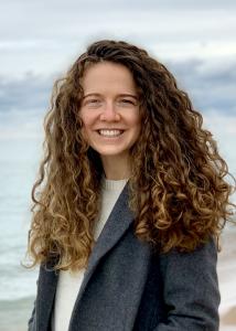 Jackson with long wavy hair and blue blazer on beach