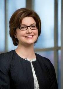 Headshot of Molly Martin with glasses and short, brown hair wearing a black jacket over a white shirt.