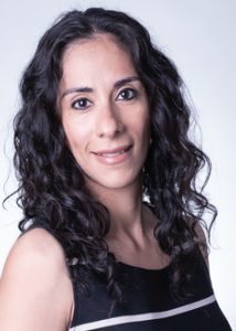 Olvera with long dark wavy hair and dark stripe top