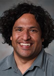 Ram with curly dark hair and gray shirt