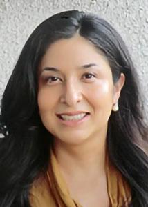 Headshot of Selena Ortiz with long dark hair wearing earrings and an orangish brown top.