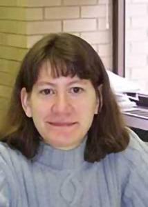 Headshot of Valarie King with mid-length, brown hair wearing a light blue sweater.