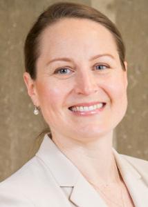 Zajacova hair pulled back, pearl earrings and blazer